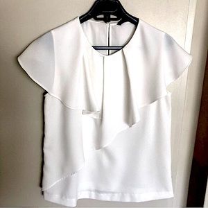 Ecru top with flowy ruffles.